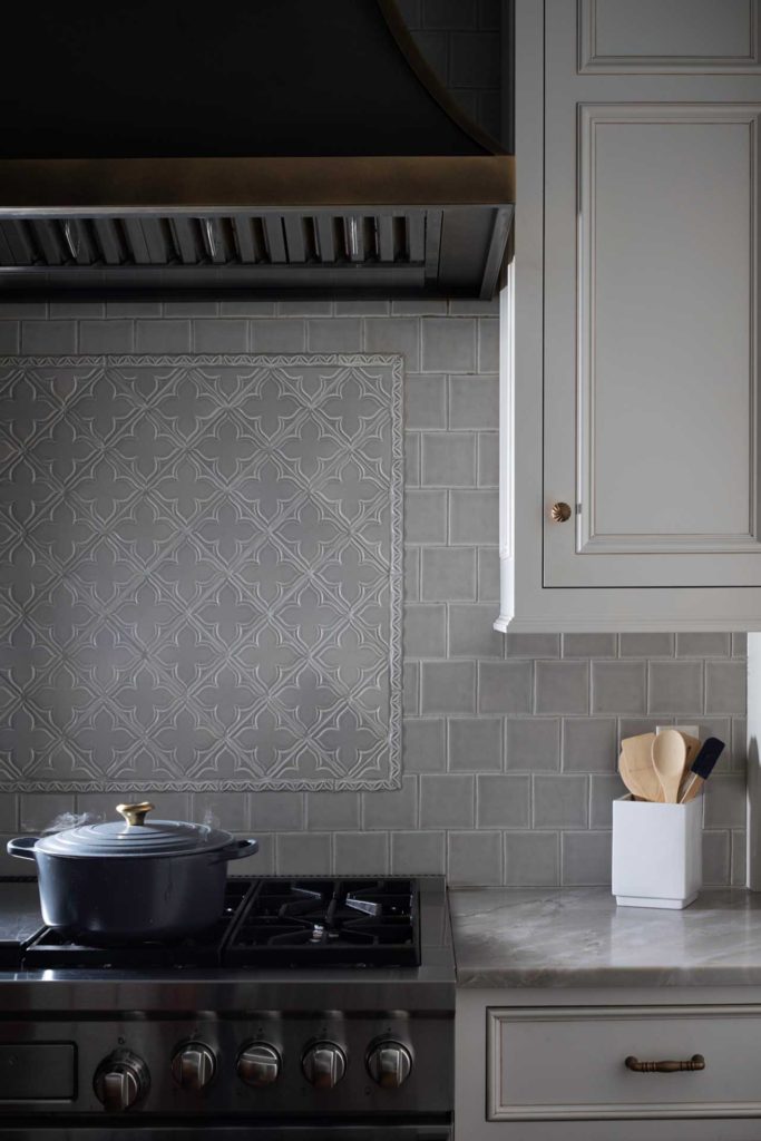 Grey tile backsplash with decorative inset