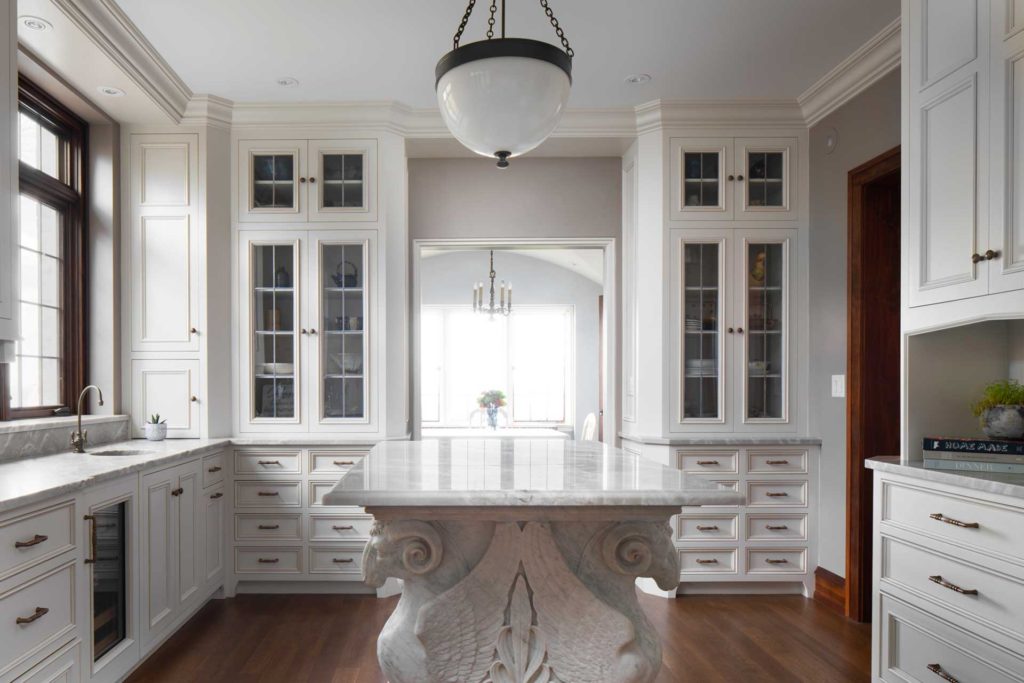 Kitchen with island supported by winged rams